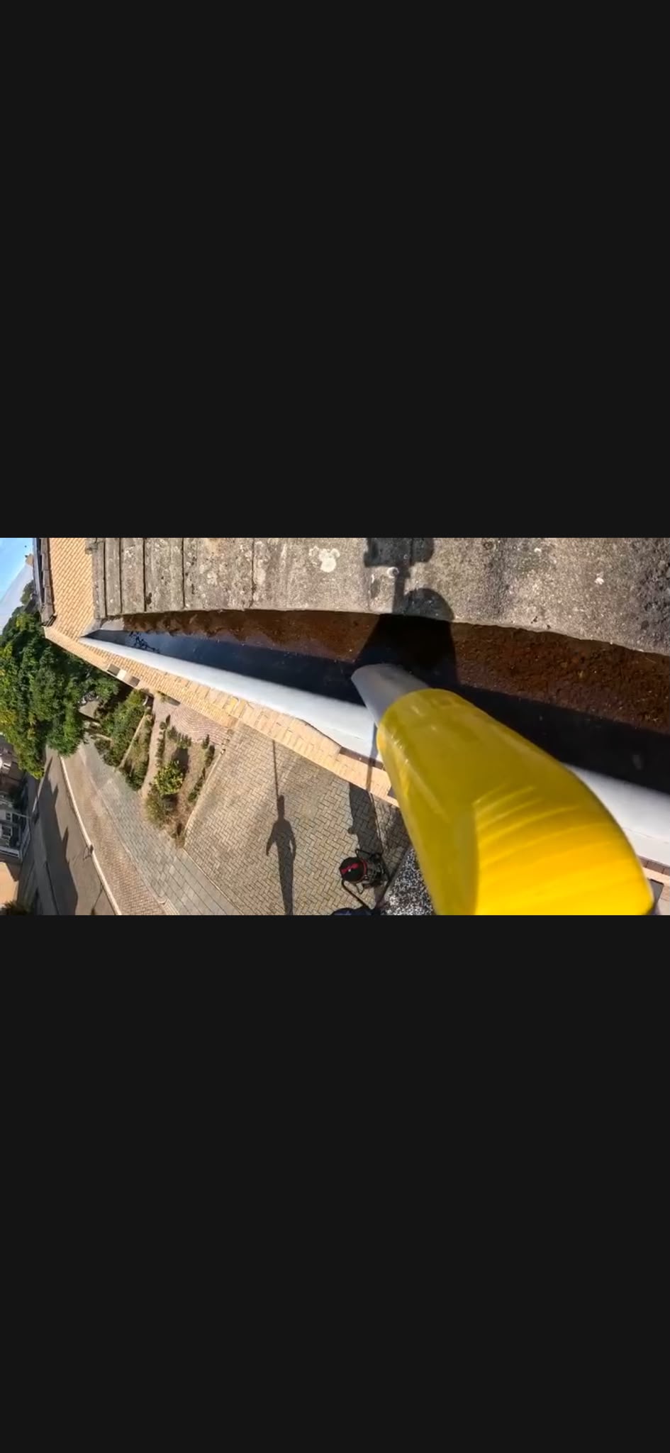 Eigen GoPro-beeld vanuit de dakgoot: de gele zuigmond bij de binnenkant van de goot en de dakgootzuiger beneden